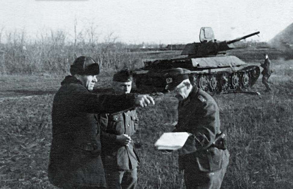 Фашисты спрашивают у местного жителя дорогу на фоне трофейного Т-34-76, 1941 г.